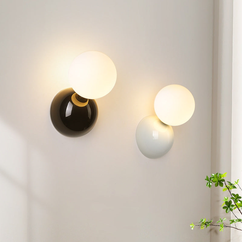 Pair of black and white Valentina globe wall lights in a room setting
