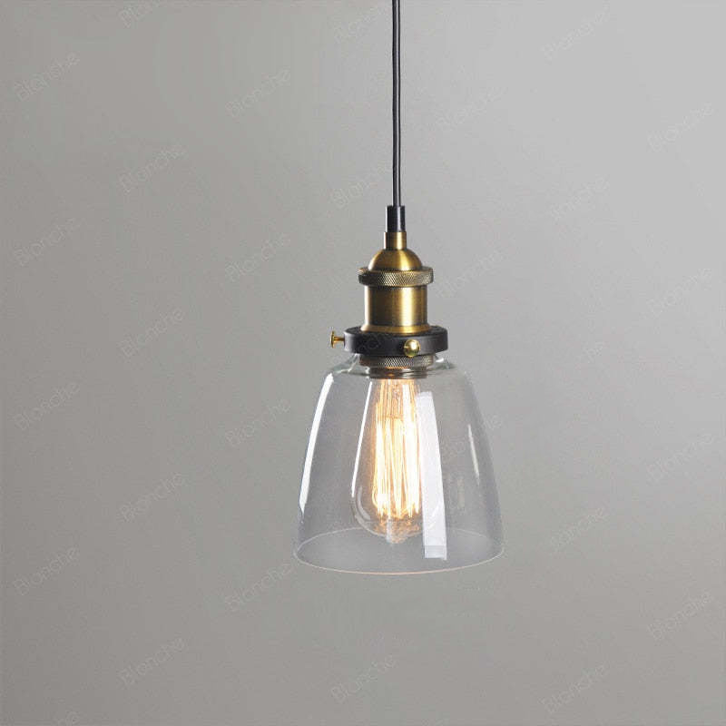 Levy Style A clear narrow cone glass pendant with a visible bulb, gold-colour fitting and black cord against grey