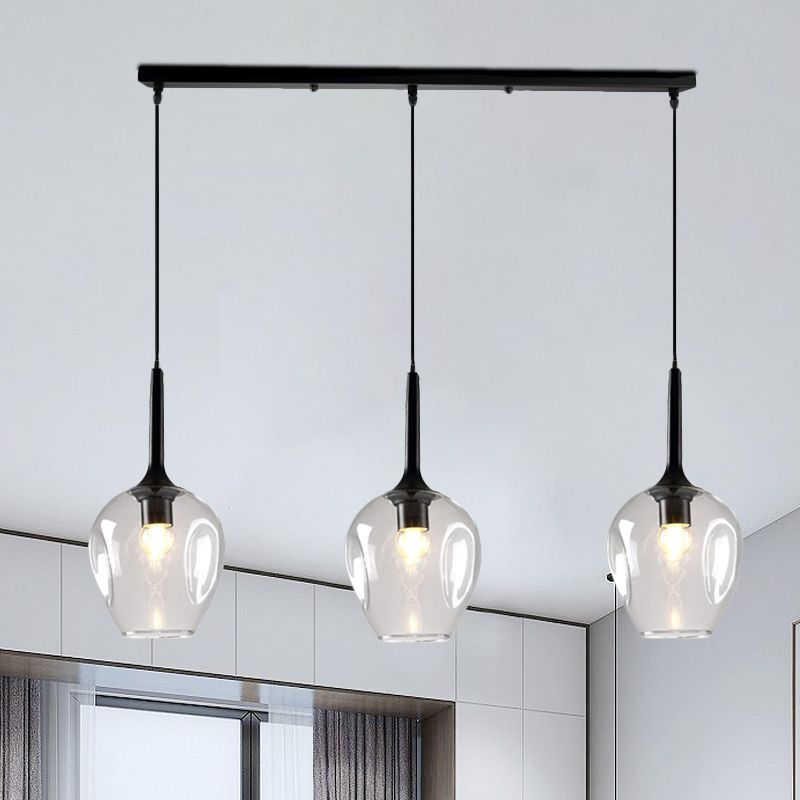 Hailie Clear glass pendant with three rounded shades in a bright room