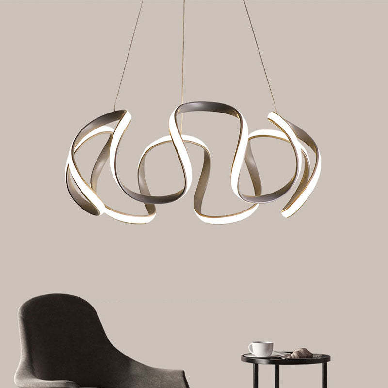 Gray curved LED flower pendant above chair and side table