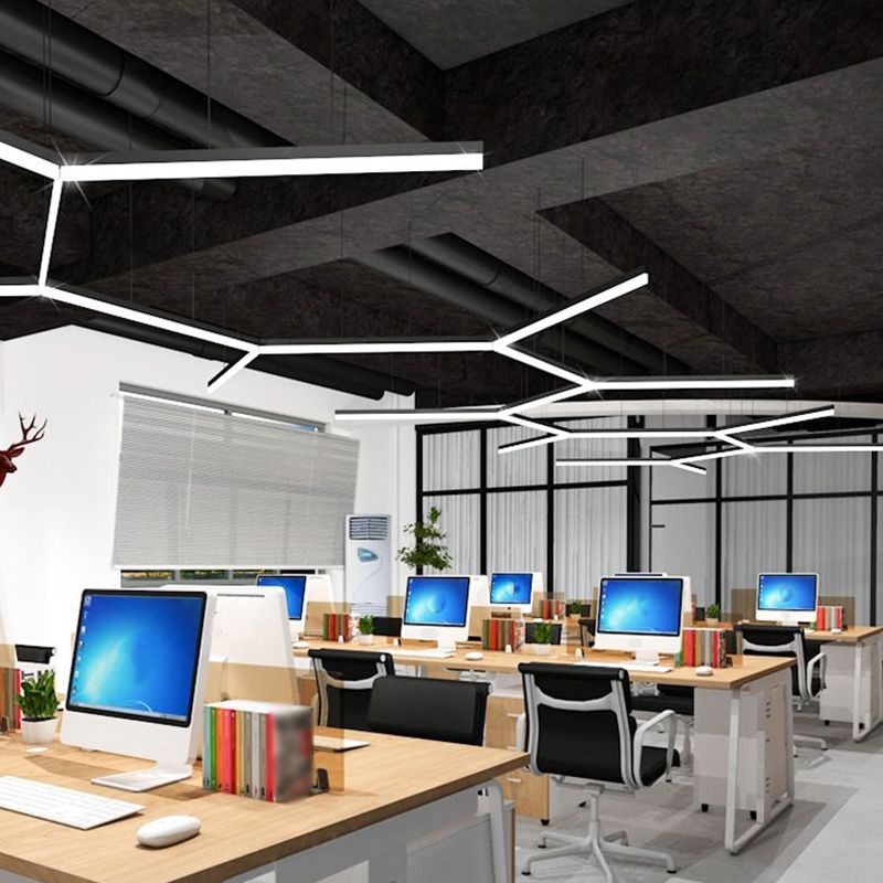 Multiple linear lights arranged across an office ceiling above desks.
