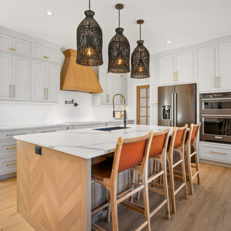 Black rattan pendant trio over a kitchen island from side view