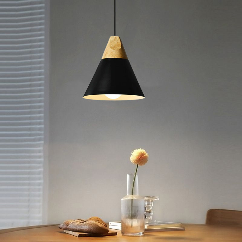Black medium cone pendant with visible bulb above a table with bread and yellow flower