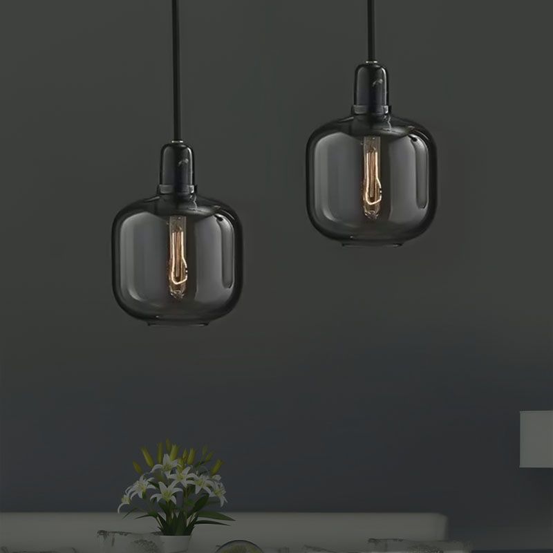 Smoke-gray glass pendant pair above a console arrangement