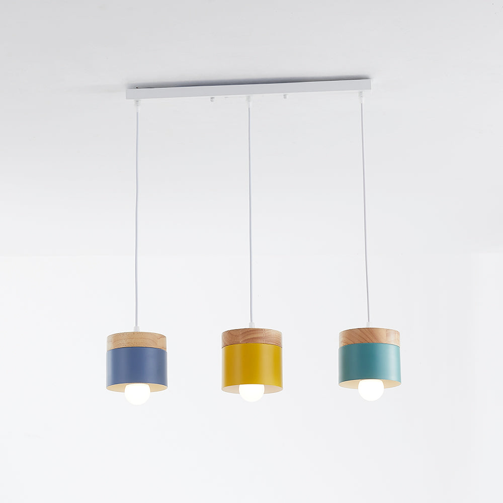 Gray, yellow and green cylindrical heads with wood accents hanging from a white rectangular canopy