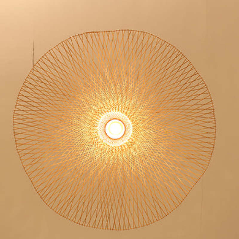 Underside of the broad woven shade with crisscross strips and a bright central opening
