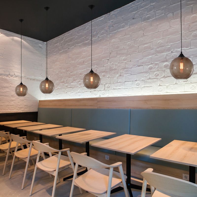 Coffee tinted glass globe pendants arranged above restaurant tables
