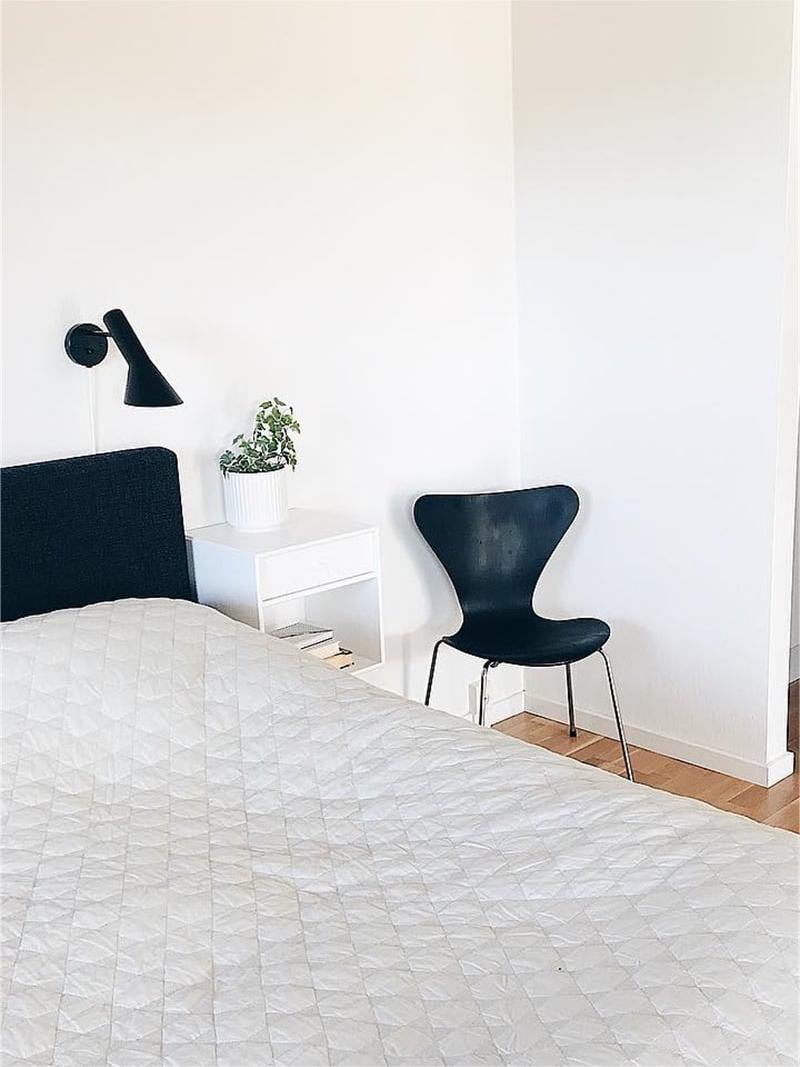 One black Calix wall light in a bright bedroom