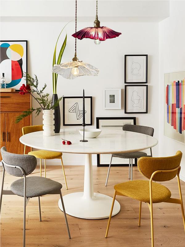 Clear, green and purple lotus pendants in a bright dining space