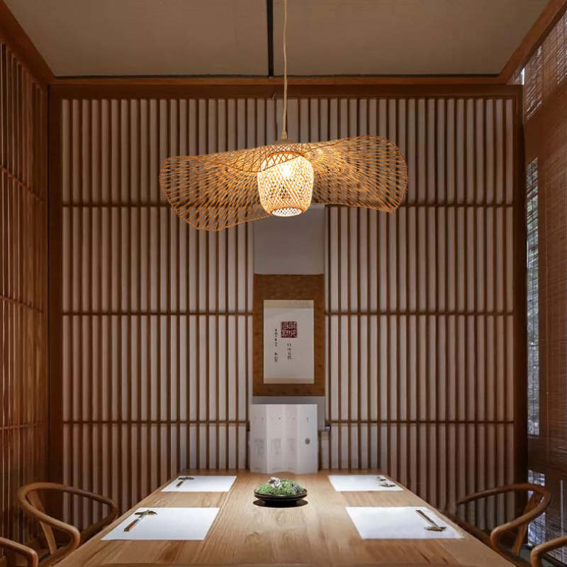Wavy woven pendant above a wood dining table in a room with slatted wood walls