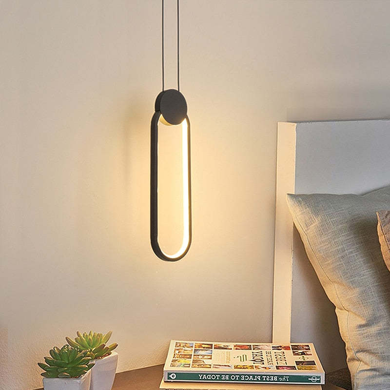 Black-and-gold long oval loop pendant by bed