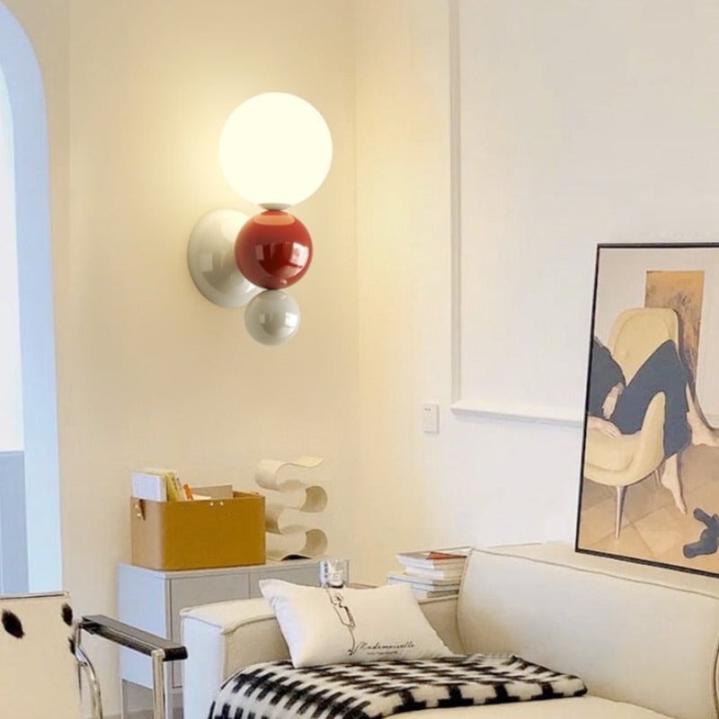Red-accent Valentina globe wall light above a yellow side table