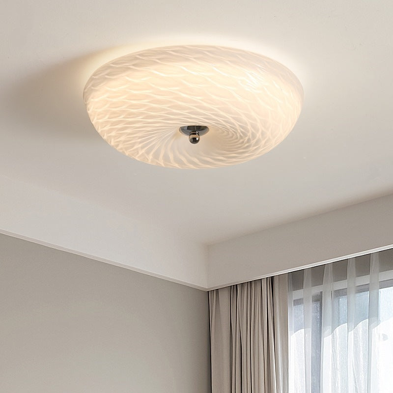 Hailie B textured glass ceiling light glowing near a window