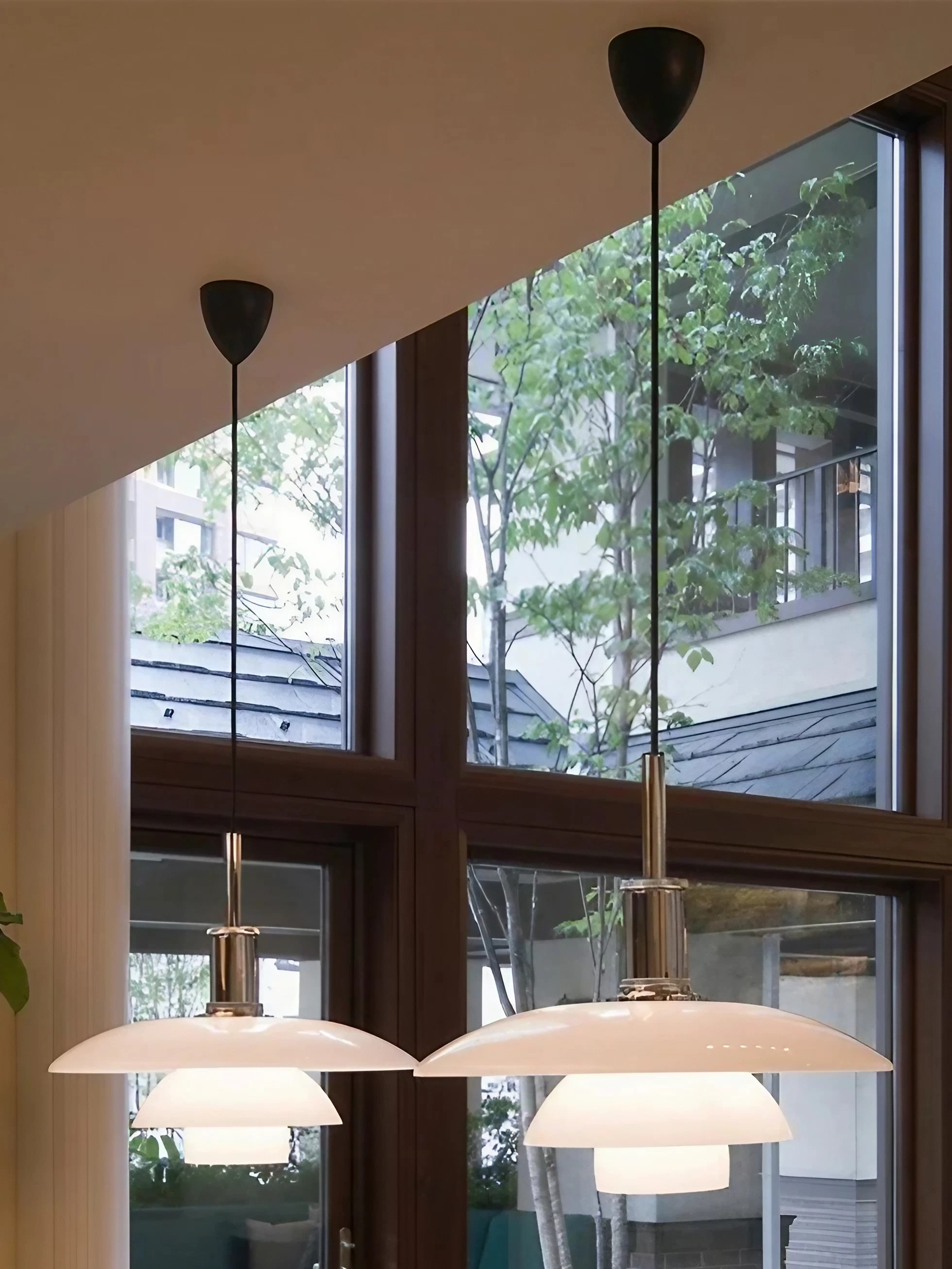 Two opal disc pendants hanging beside tall windows