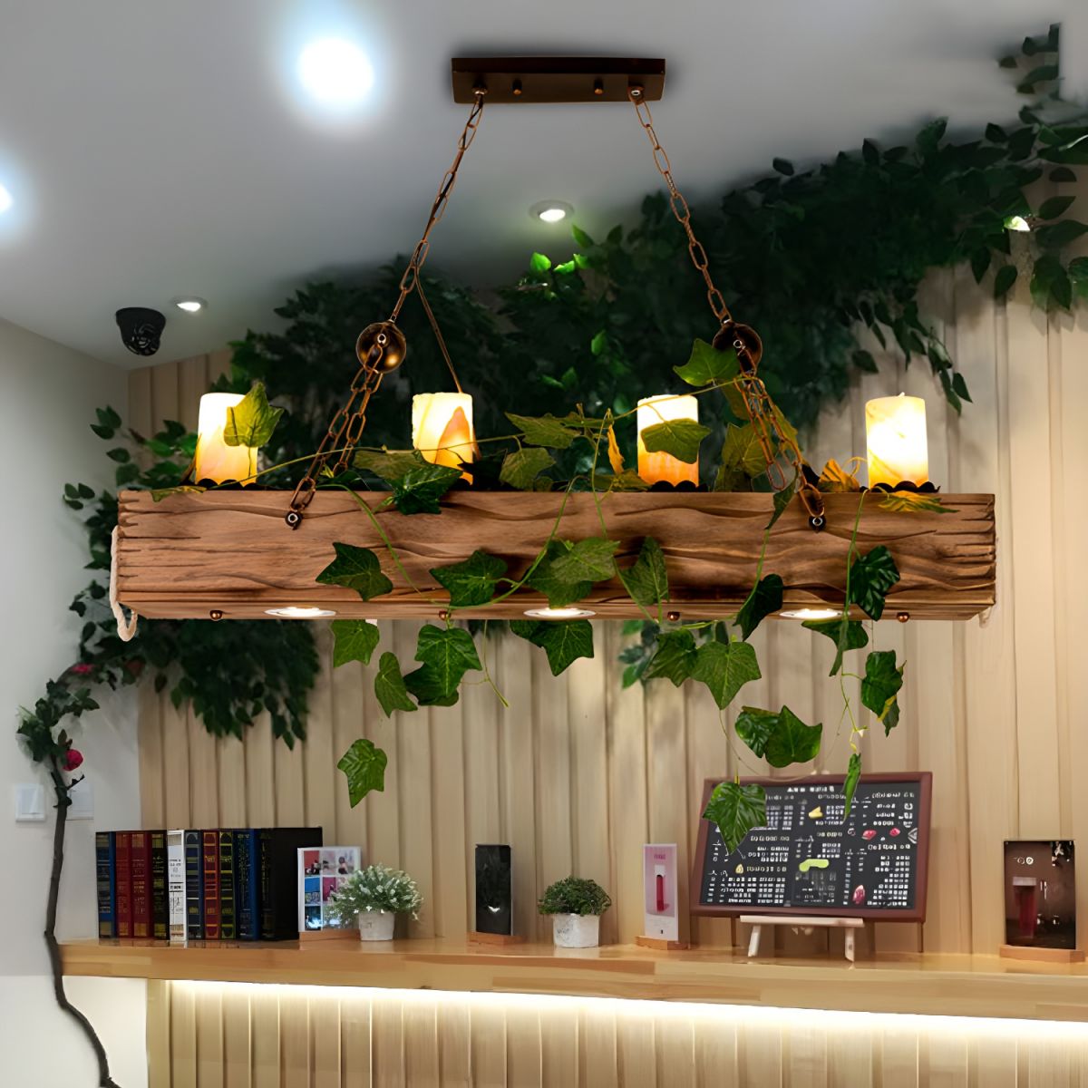 Austin wood-grain pendant with candle-style lights and leafy vines hanging above an indoor counter.