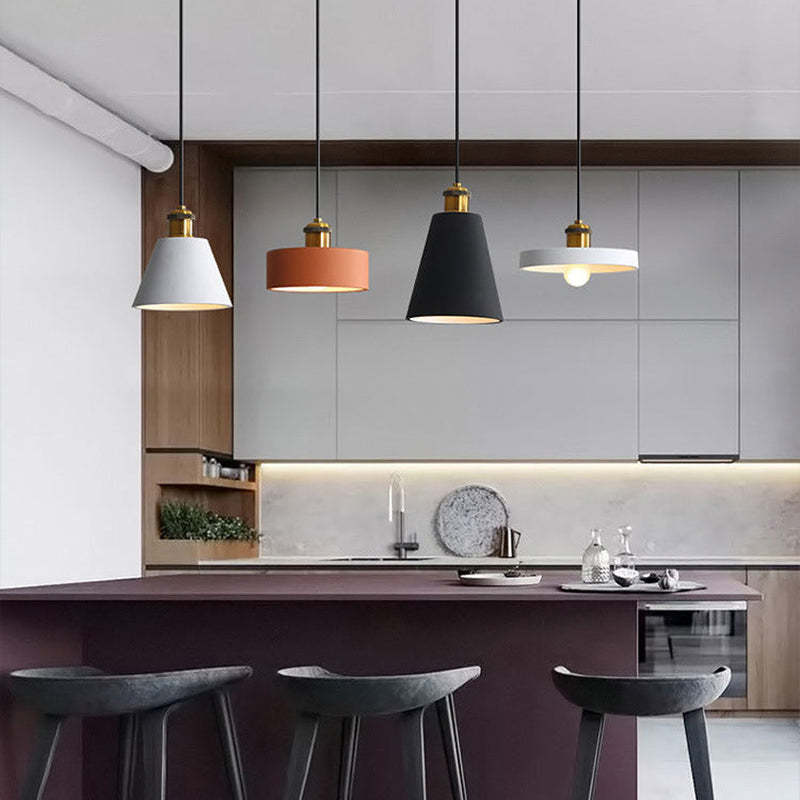 Four differently shaped Morandi pendants above a kitchen island.