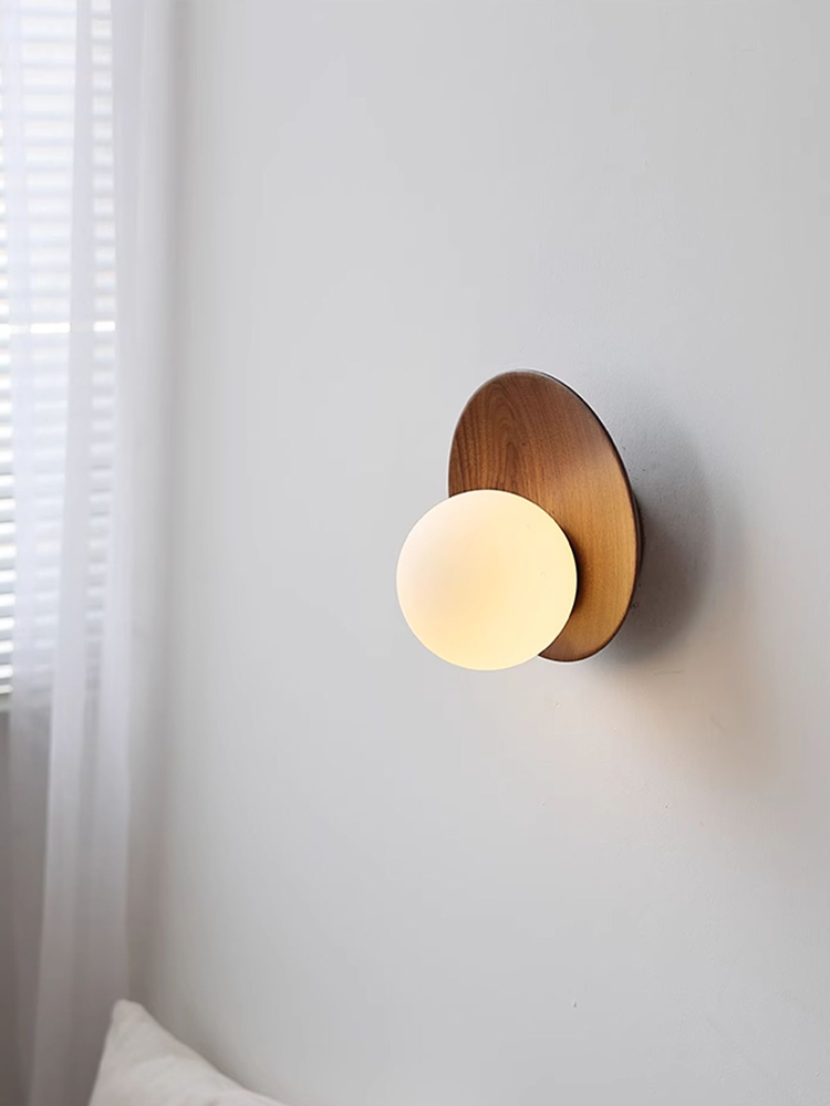 Angled view of the Lunetta glowing globe against a walnut disc