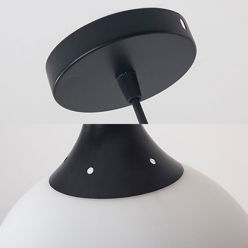 Detail collage of black round canopy and cord fitting above tapered black neck at white globe, with small round holes