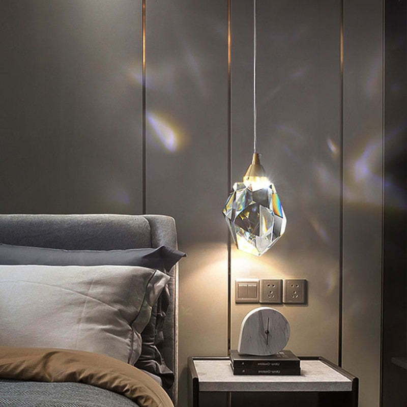 Single Kristy crystal pendant beside a bed and a small dark nightstand