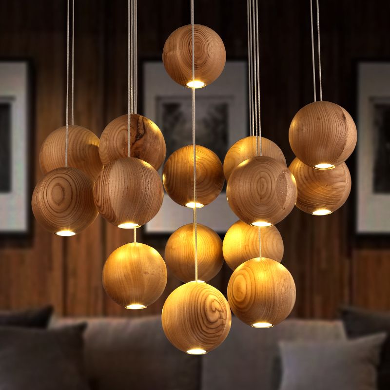 Warmly lit wood-grain globe pendant cluster above a sofa