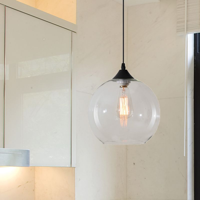 Clear glass globe pendant beside a window