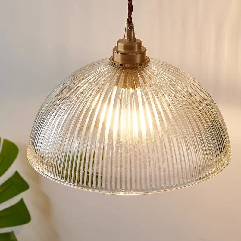 Lit Alessio glass dome showing vertical ribs and a gold-coloured holder