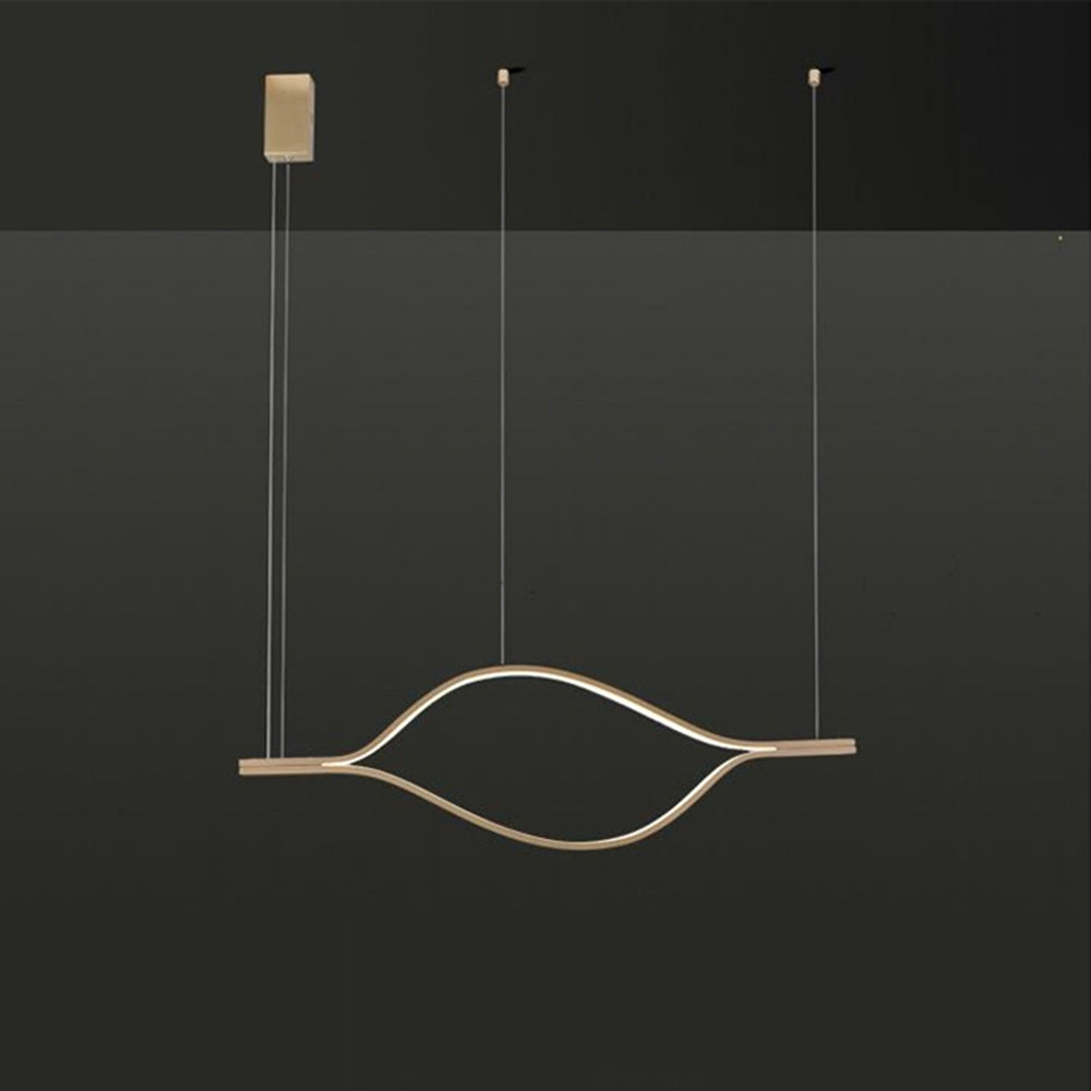 Smaller gold-tone eye-shaped pendant with ceiling hardware against dark gray