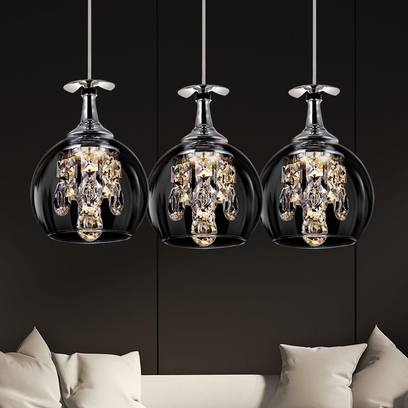 Three rounded Kristy clear glass pendants with hanging drops above a pale sofa.