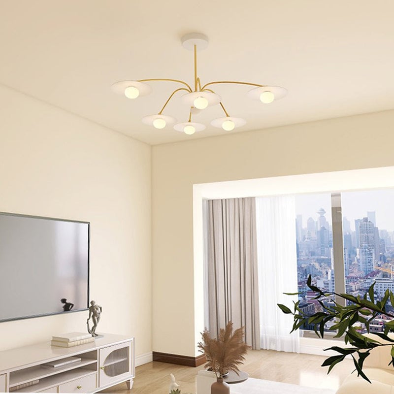 White-and-gold Cairns pendant above a television console in a pale living room beside a city-view window