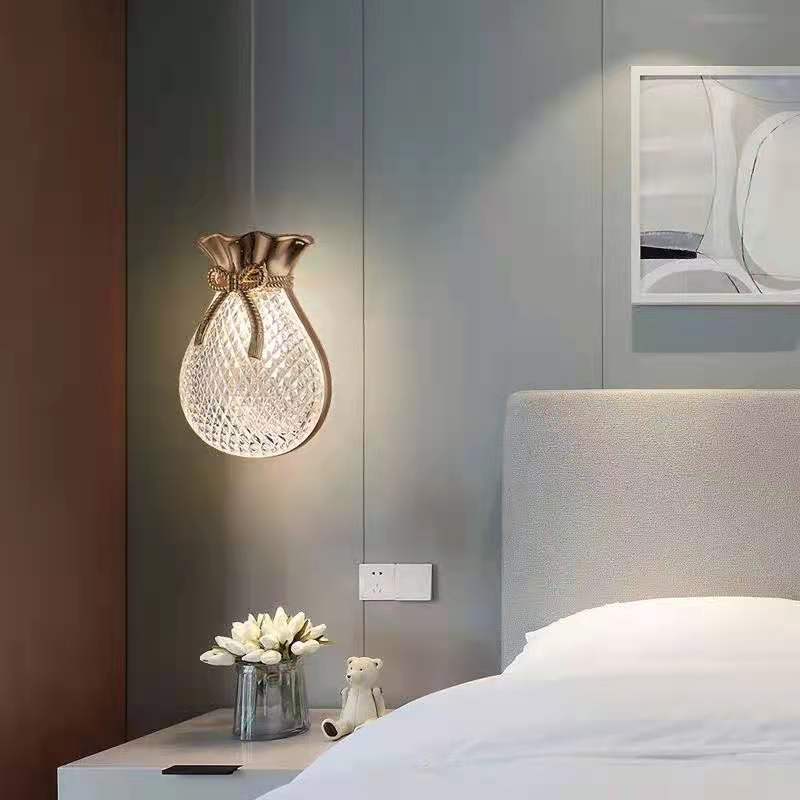Hailie Style A pouch-shaped pendant beside a pale bed and framed artwork.