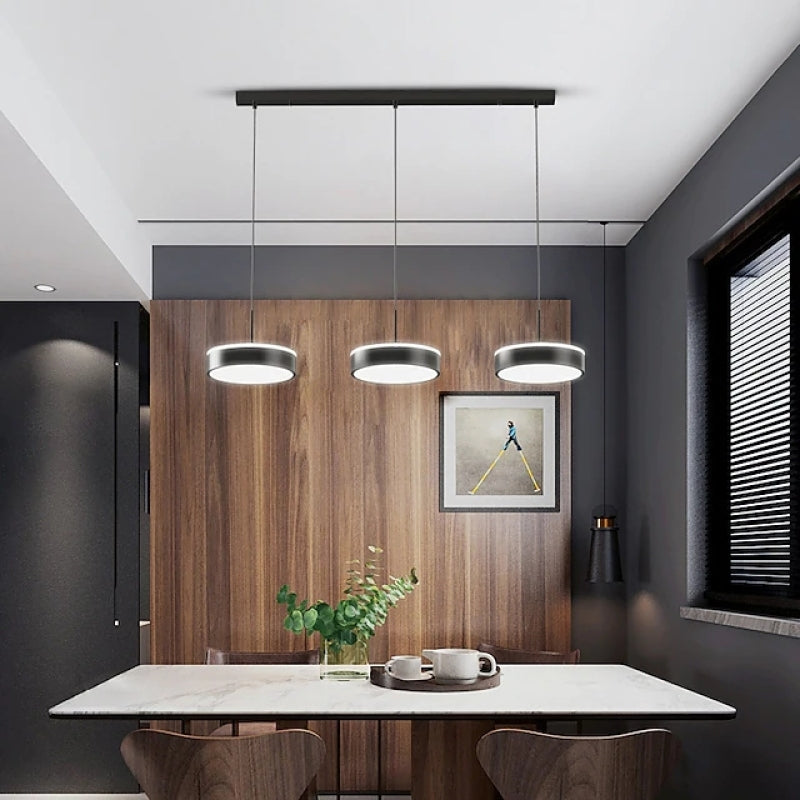 Raheel illuminated disc heads above a dining table against wood panelling.