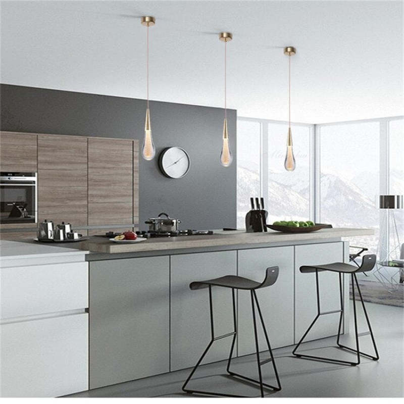 Three gold-and-crystal drop pendants above a kitchen island