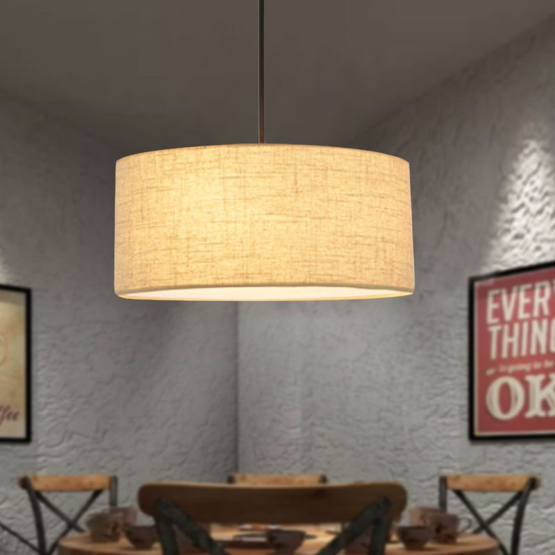 Beige Renée drum shade glowing above a dining table