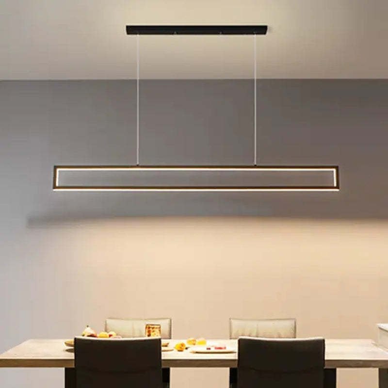 Edge rectangular pendant above a dining table and dark chairs