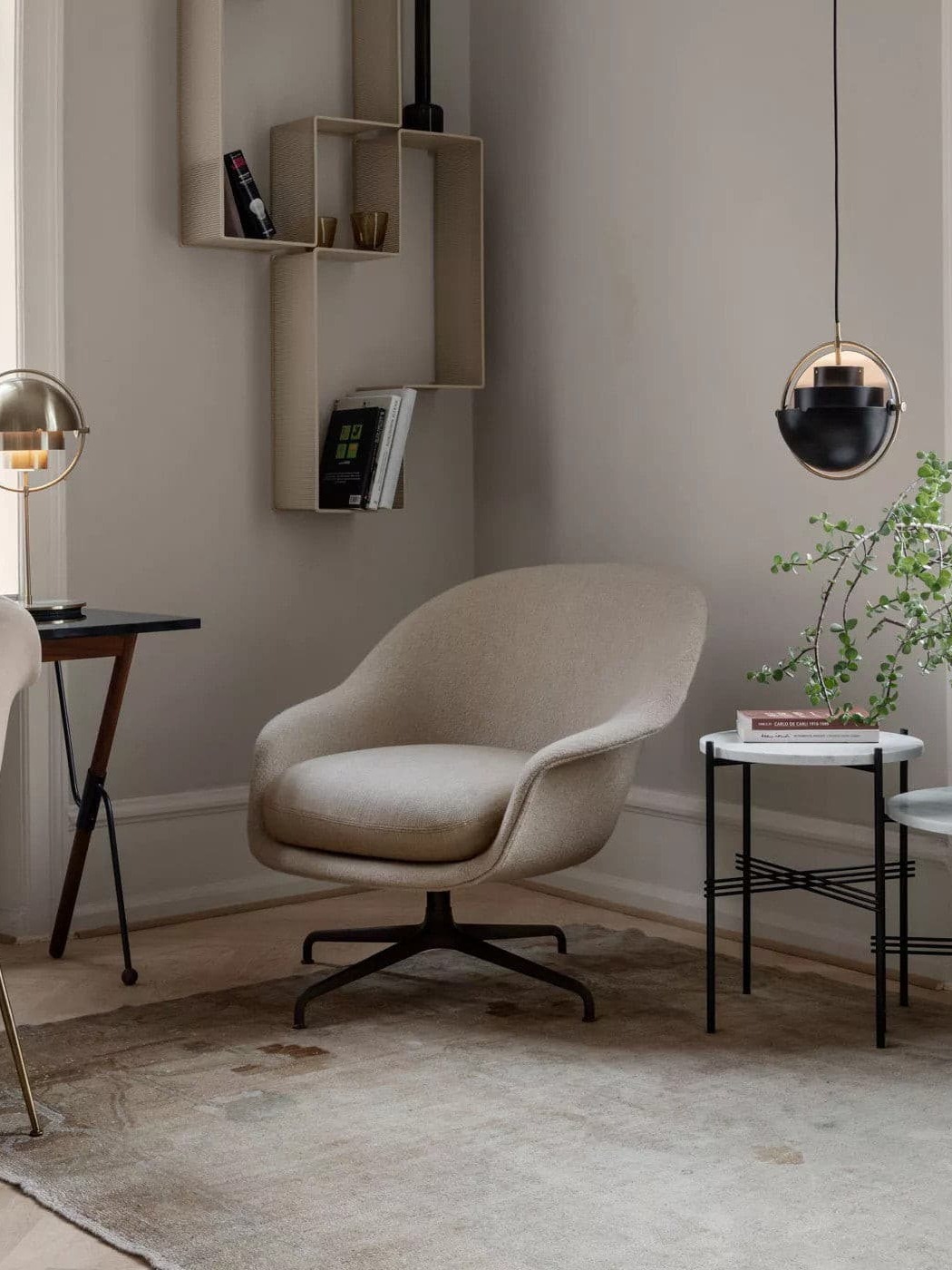 Black ring-framed pendant beside a lounge chair