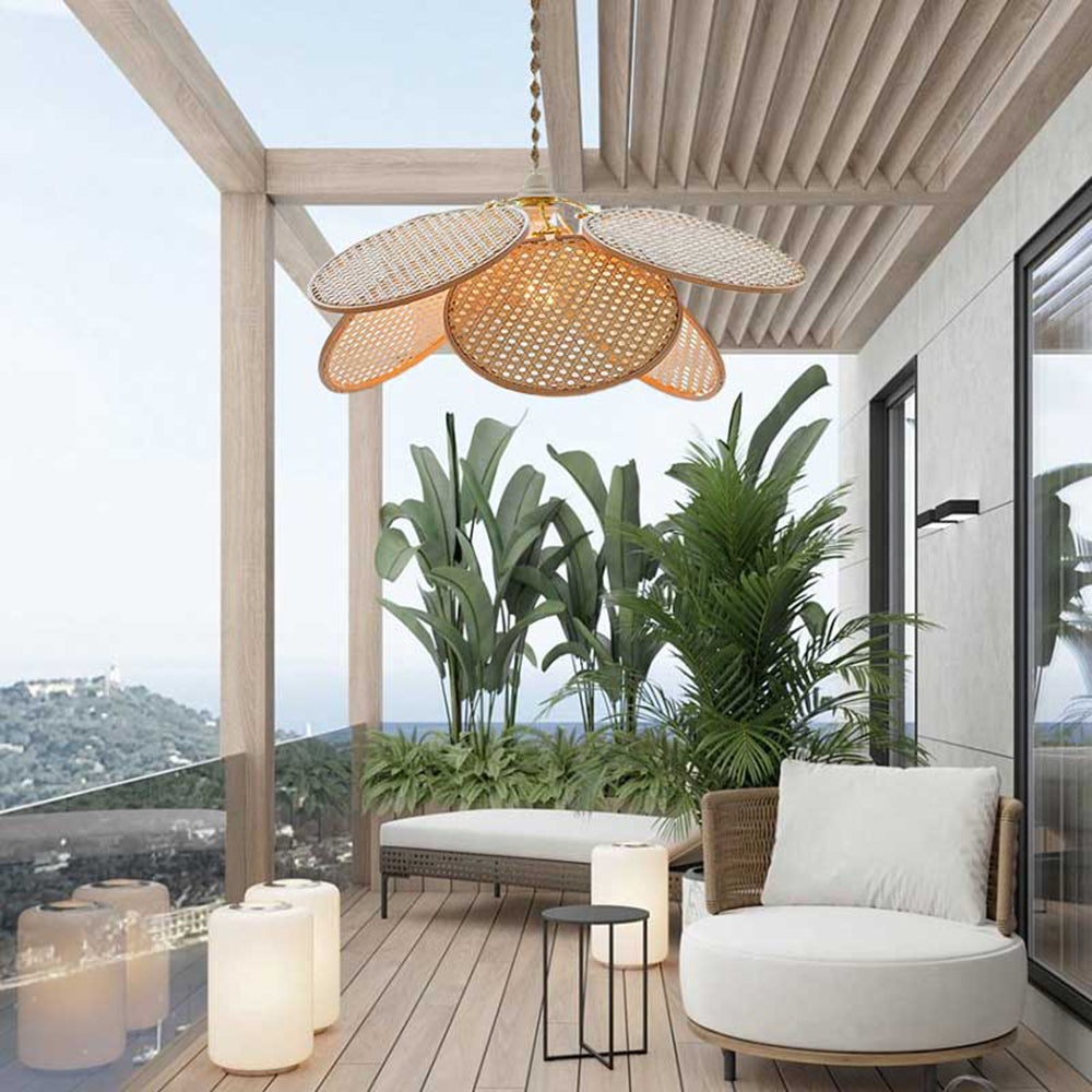 Woven petal pendant pictured above white terrace seating, plants and decking beneath a roof beside glass railings
