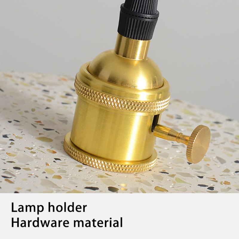 Close-up of gold-tone lamp holder with knurled rings, round side knob and black cord connector