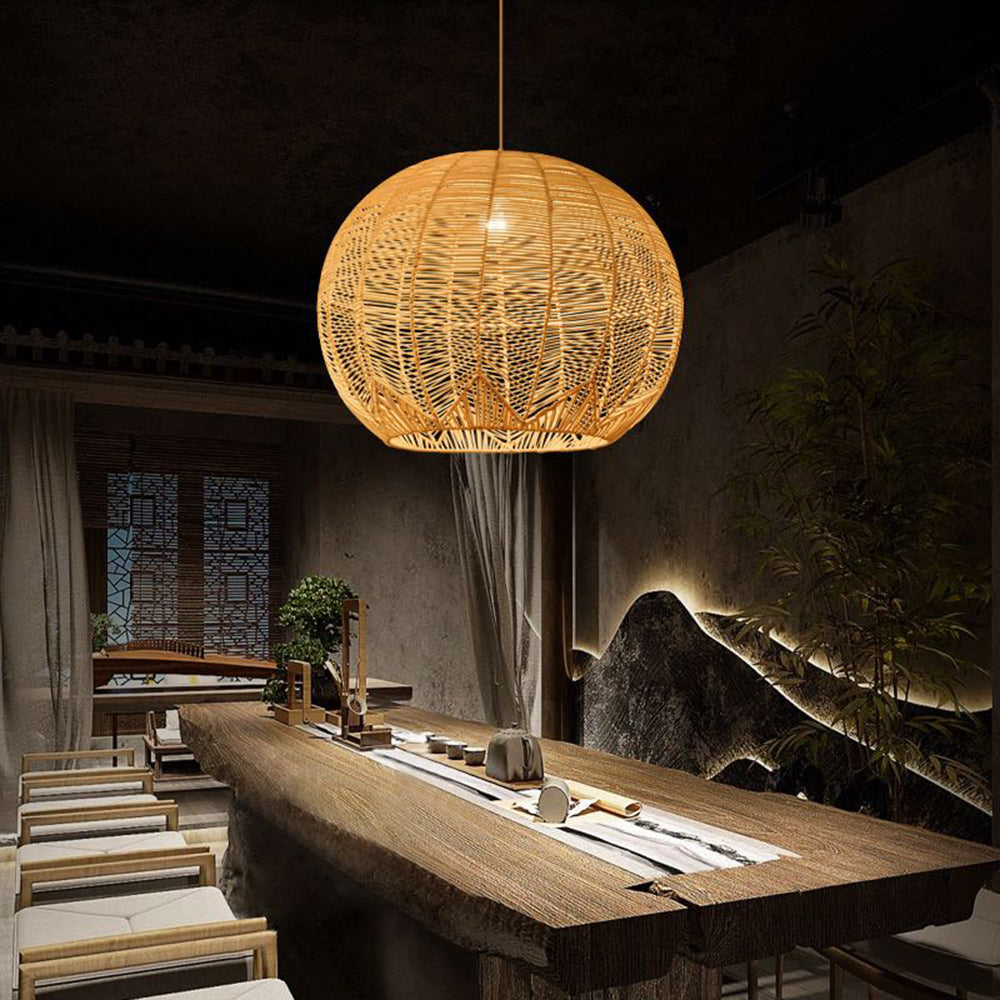 Ritta pendant over a long wood table with a white runner and tea ware, light chairs, a tall plant and illuminated mountain wall decor.