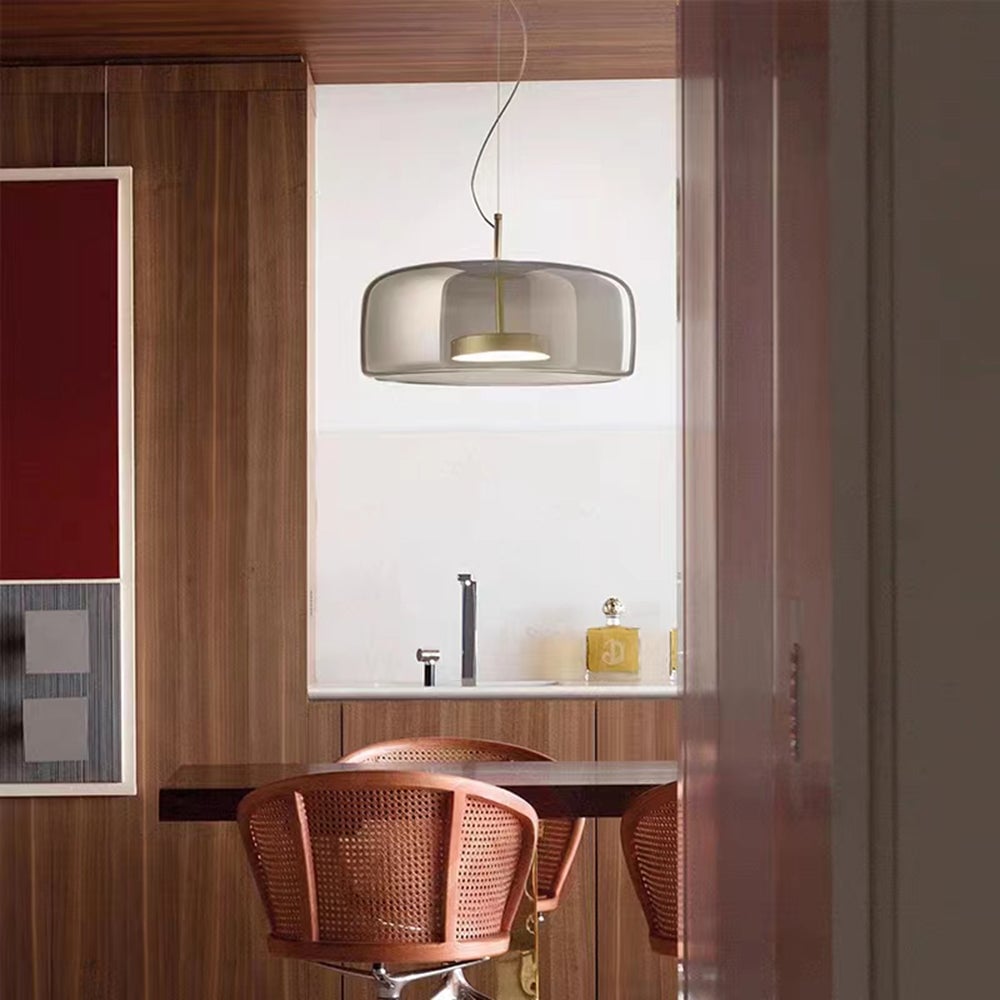 Hailie tinted glass pendant above a desk beside a wooden wall
