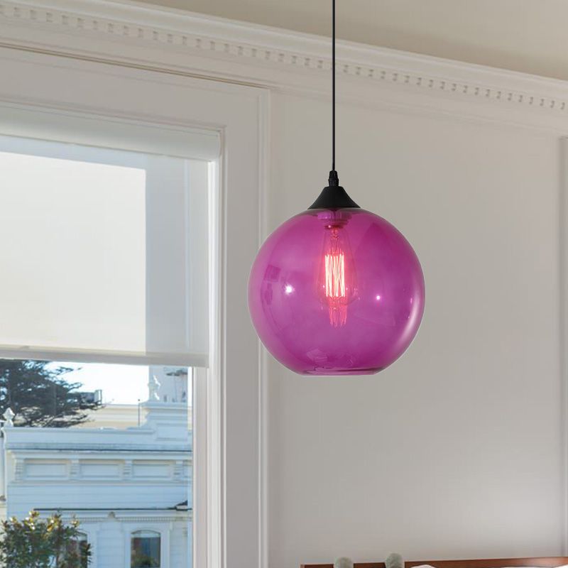 Purple glass globe pendant against pale wall