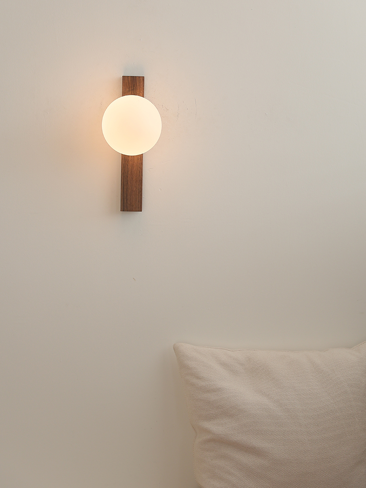 Front view of the glowing Lunaria globe and vertical walnut bar