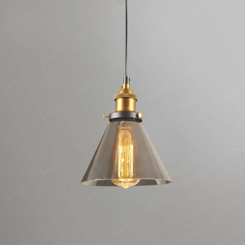 Levy Style B smoke-gray wide cone glass pendant with gold-colour fitting, black cord and illuminated bulb against grey