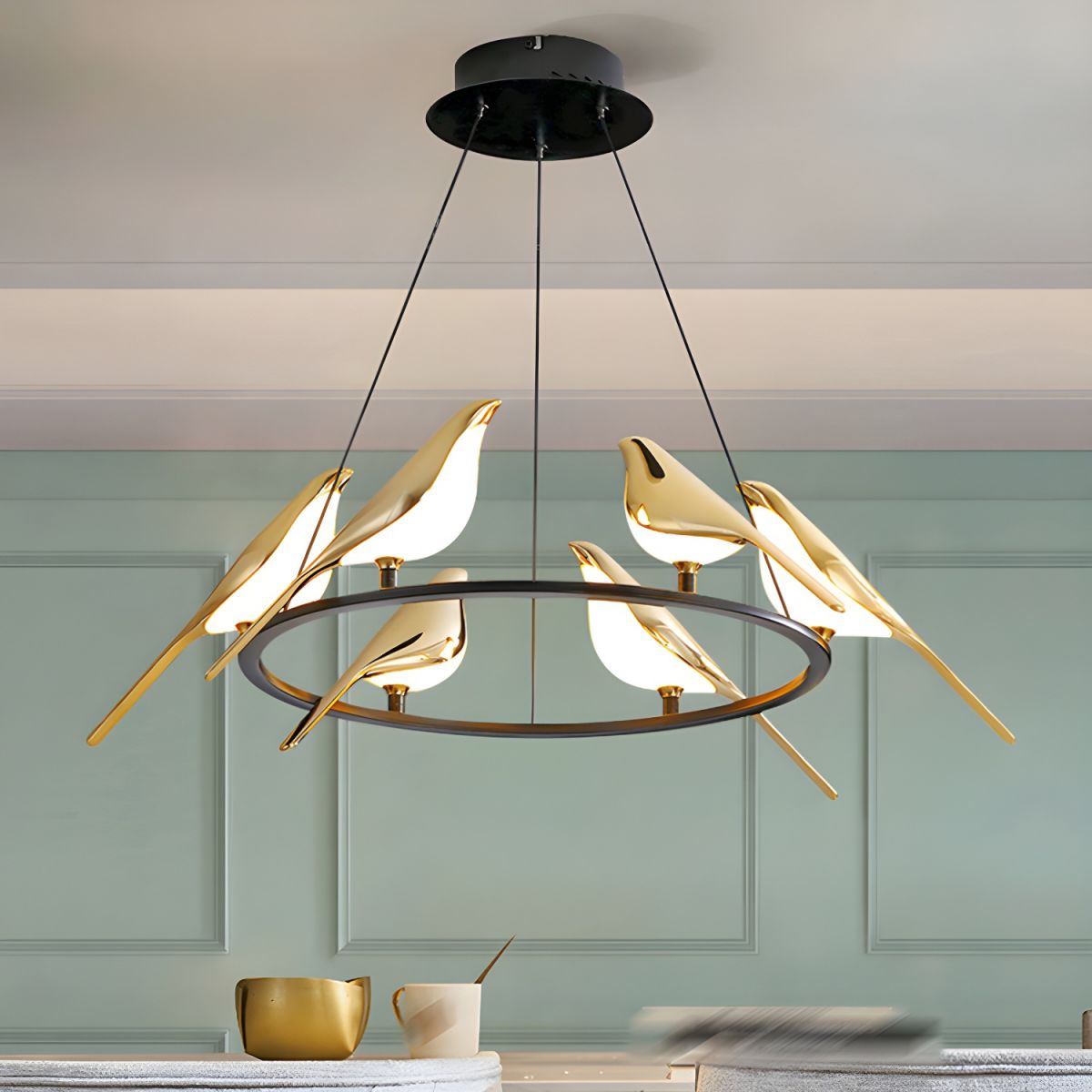 Six-bird ring pendant against pale green wall