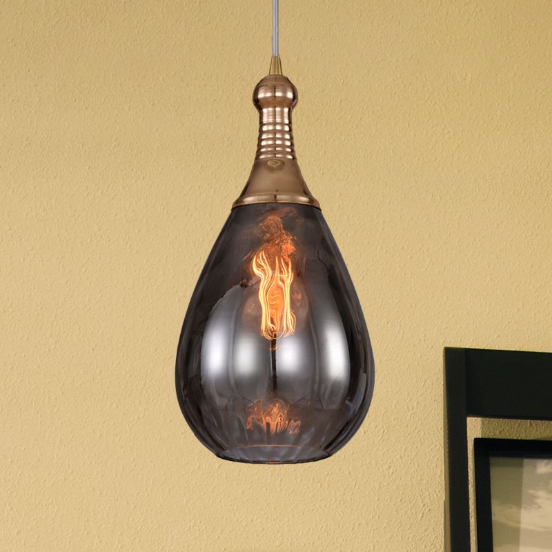 Avi Brass-Smoke Gray pendant against a warm-coloured wall