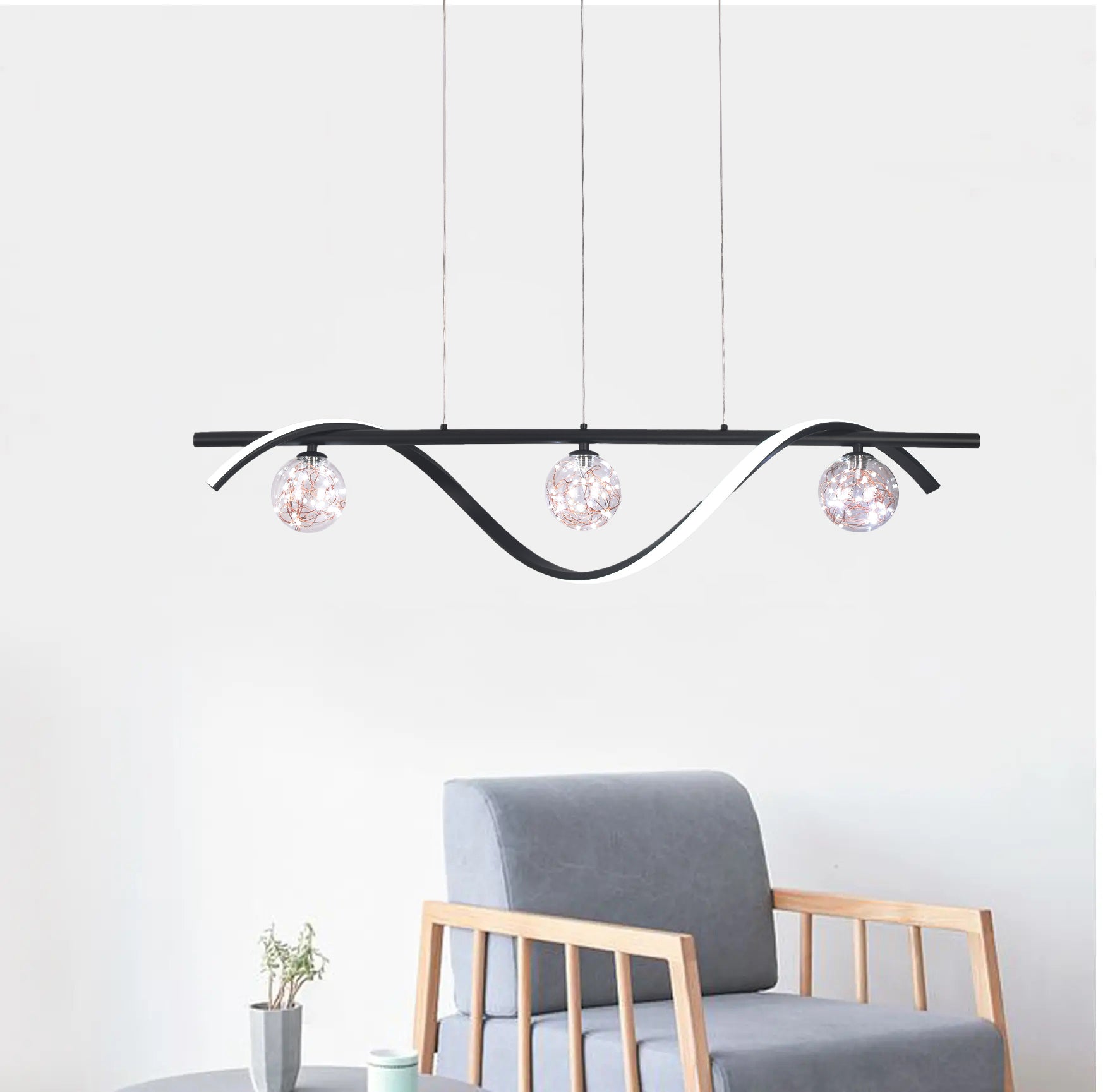 Black three-globe wave pendant above a chair