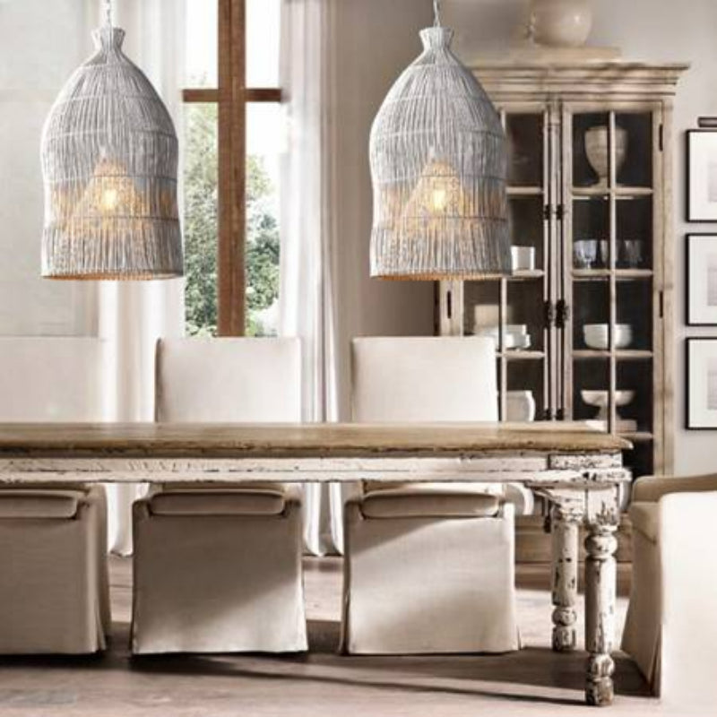 Two white woven rattan pendants above a dining table