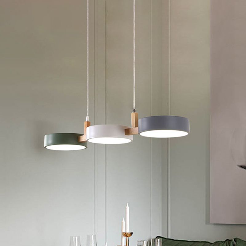 Three-head wood-and-metal lamp suspended above a room