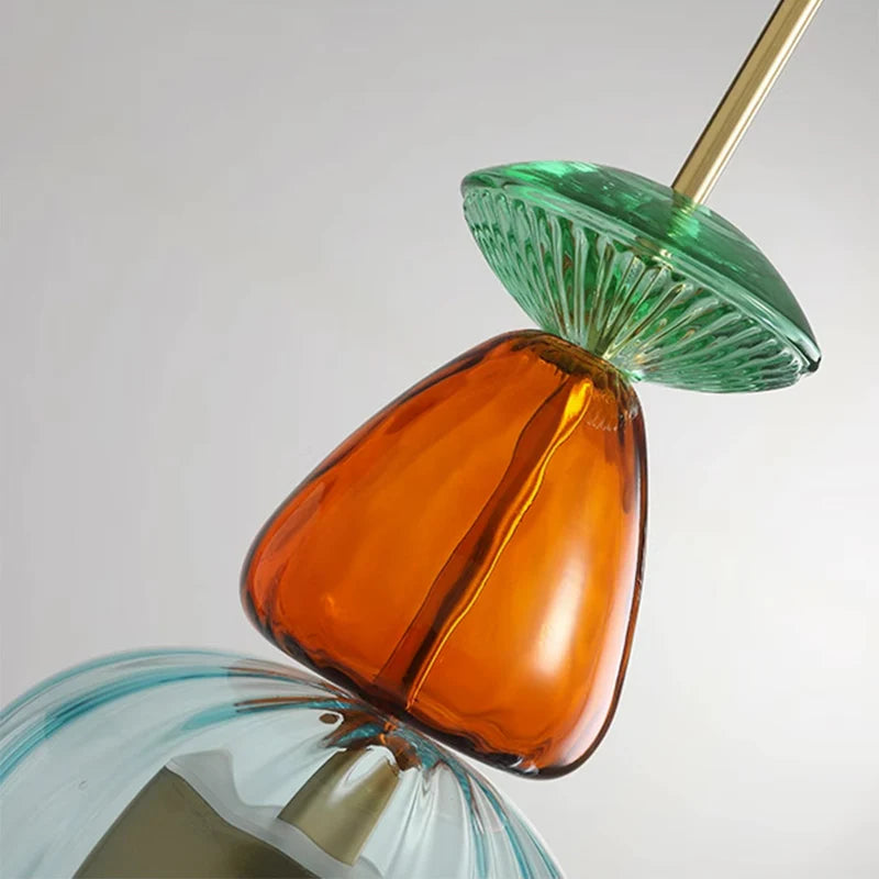 Amber glass ornament below green ribbed glass disk