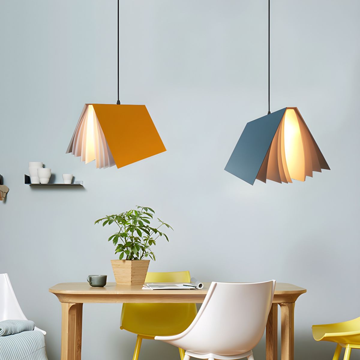Yellow and blue book pendants above a small dining table