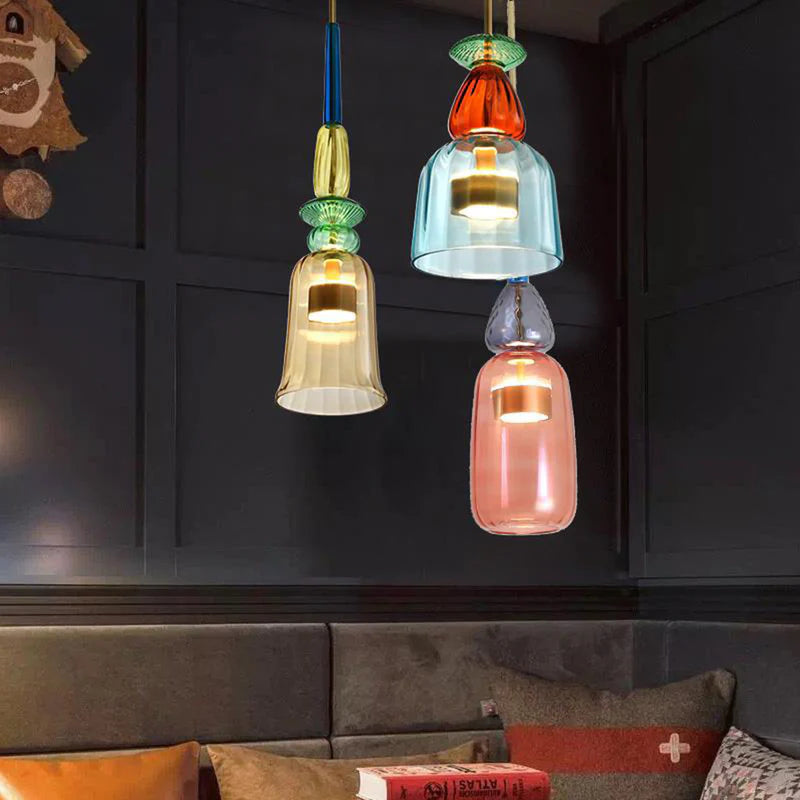 Three glass pendants with gold blue and pink shades in dark room